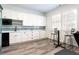 Bright kitchenette with sleek white cabinets, modern appliances, bar table and chairs, and stylish striped backsplash at 341 Little Pine Ln, Woodstock, GA 30188