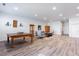Open living room showcasing a pool table, stylish seating, and hardwood floors at 341 Little Pine Ln, Woodstock, GA 30188
