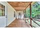 Covered back porch with wooden floor and railing overlooking a lush, wooded yard at 4481 Mclain Cir, Acworth, GA 30101
