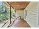 Covered back porch with wooden floor and railing overlooking a lush, wooded yard at 4481 Mclain Cir, Acworth, GA 30101