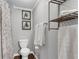 Bathroom with a toilet, artwork, and shelving for towel and toiletry storage at 4481 Mclain Cir, Acworth, GA 30101