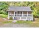Charming cottage-style home featuring a screened front porch and a lush, wooded lot at 4481 Mclain Cir, Acworth, GA 30101
