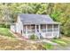 Charming cottage-style home featuring a screened front porch and a lush, wooded lot at 4481 Mclain Cir, Acworth, GA 30101