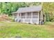 Charming cottage-style home featuring a screened front porch and a lush, wooded lot at 4481 Mclain Cir, Acworth, GA 30101