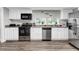 Functional kitchen boasting stainless steel appliances, pristine white cabinetry, and durable laminate flooring at 4481 Mclain Cir, Acworth, GA 30101