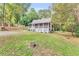 Lovely yard with cottage-style home featuring a screened front porch and a lush, wooded lot at 4481 Mclain Cir, Acworth, GA 30101