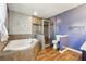 Bathroom featuring a jacuzzi tub, separate glass shower, and wood-look floor at 1108 Gwens Sw Trl, Lilburn, GA 30047