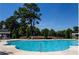 Community swimming pool with clean blue water, surrounded by seating and landscaping for relaxation and recreation at 4397 Challedon Dr, South Fulton, GA 30213