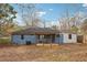 Full backyard view of a blue brick house, showcasing a covered back porch and a spacious yard with mature trees at 2336 Mark Trl, Decatur, GA 30032