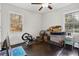 Bedroom showcasing natural light, hardwood floors, a ceiling fan, and a dedicated exercise area with an elliptical machine at 2336 Mark Trl, Decatur, GA 30032