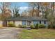 Charming single-story home featuring a light blue brick facade, well-maintained lawn, and mature trees at 2336 Mark Trl, Decatur, GA 30032