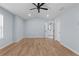 Bright, airy bedroom with light blue walls, hardwood floors, and ceiling fan; open doorway to bathroom at 3266 Spicy Cedar Ln, Lithonia, GA 30038