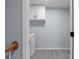 Functional laundry room with washer, dryer, and upper cabinets for storage, featuring light gray tile flooring at 3266 Spicy Cedar Ln, Lithonia, GA 30038