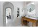 Bright bathroom with a vintage vanity, arched doorways, and white paneled walls at 455 Peachtree Battle Nw Ave, Atlanta, GA 30305