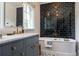 Charming bathroom with black subway tile wall, classic white bathtub, and gray vanity with marble countertop at 455 Peachtree Battle Nw Ave, Atlanta, GA 30305