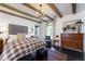 Comfortable bedroom with wood beam ceiling, dark wood floors, and a plaid comforter at 455 Peachtree Battle Nw Ave, Atlanta, GA 30305