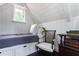 Attic bedroom space with single bed, white walls, and a reading chair at 455 Peachtree Battle Nw Ave, Atlanta, GA 30305