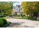 Elegant home with stone and stucco exterior, well-manicured landscaping, and a circular driveway at 455 Peachtree Battle Nw Ave, Atlanta, GA 30305