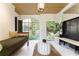 Bright sitting area with exposed brick, wood ceiling, daybed, and views of landscaped yard at 455 Peachtree Battle Nw Ave, Atlanta, GA 30305