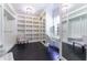 Spacious walk-in closet with custom shelving, mirrored doors, dark wood flooring, and a vanity area at 455 Peachtree Battle Nw Ave, Atlanta, GA 30305