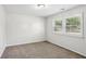 Neutral bedroom with carpet and window featuring bright natural light and shutter-style blinds at 875 Waterbrook Ct, Roswell, GA 30076