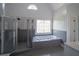 Bathroom featuring a large tub and separate shower with decorative leaded-glass window at 1458 Sweet Bottom Cir, Marietta, GA 30064