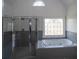 Bright bathroom featuring a large tub and separate shower with leaded glass, complemented by neutral finishes at 1458 Sweet Bottom Cir, Marietta, GA 30064