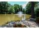 Scenic pond with a fountain, surrounded by greenery and a patio area at 28303 Plantation Ne Dr # 303, Atlanta, GA 30324