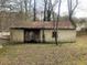 Exterior view of an outbuilding with a weathered metal roof and aging siding at 339 Kelly Mill Rd, Cumming, GA 30040