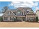 Attractive two-story home with stone and brick accents, professionally landscaped at 504 Taymack Farm Ct, Woodstock, GA 30188