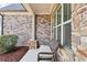 Inviting front porch with brick detailing and stone accents, a perfect spot to relax at 504 Taymack Farm Ct, Woodstock, GA 30188