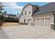 View of the home's side and rear featuring a three-car garage and concrete driveway at 504 Taymack Farm Ct, Woodstock, GA 30188