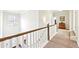 Bright hallway with white railings, chandelier, neutral carpet and an ornate wooden dresser at 504 Taymack Farm Ct, Woodstock, GA 30188