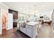 Stylish kitchen with island seating, stainless steel sink, and open access to the living room, perfect for entertaining at 504 Taymack Farm Ct, Woodstock, GA 30188