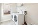 Well-lit laundry room with modern washer, dryer, storage shelving and window at 504 Taymack Farm Ct, Woodstock, GA 30188