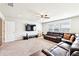 Spacious living room featuring a plush sectional sofa, large TV, and neutral carpeting at 504 Taymack Farm Ct, Woodstock, GA 30188