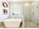 Bright main bathroom with soaking tub, glass-enclosed shower, and modern fixtures at 504 Taymack Farm Ct, Woodstock, GA 30188
