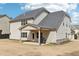 Exterior view of the home's rear with a covered patio, neutral siding, and a dark roof at 504 Taymack Farm Ct, Woodstock, GA 30188