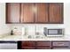 This wet bar features dark cabinets, a granite countertop, stainless steel sink, and a mini refrigerator at 504 Taymack Farm Ct, Woodstock, GA 30188