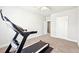 Workout room showcasing a treadmill, neutral carpeting, and interior door at 504 Taymack Farm Ct, Woodstock, GA 30188
