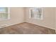 Cozy bedroom featuring plush carpet, neutral-toned walls, and two bright windows at 1883 Windsor Sw Dr, Atlanta, GA 30311