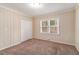 This bedroom features a neutral color scheme, wood paneling, and a window that provides ample natural light at 1883 Windsor Sw Dr, Atlanta, GA 30311