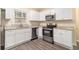 Updated kitchen featuring granite countertops, white cabinets, and stainless steel appliances at 1883 Windsor Sw Dr, Atlanta, GA 30311