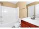 Clean bathroom featuring a shower-tub, toilet, and vanity with a cherry wood cabinet at 4678 Ravenwood Loop, Union City, GA 30291