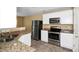 Kitchen boasts stainless steel appliances, granite countertops, and white cabinets at 4678 Ravenwood Loop, Union City, GA 30291