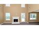 Sunlit living room features a fireplace, large windows, and a neutral color scheme at 4678 Ravenwood Loop, Union City, GA 30291