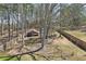 Spacious backyard with mature trees, a wooden fence, a swing, a shed, and a pergola-covered seating area at 780 Mccart Rd, Lawrenceville, GA 30045