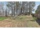 Spacious backyard with mature trees, a wooden fence, a swing, and a pergola-covered seating area at 780 Mccart Rd, Lawrenceville, GA 30045