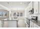 Well-lit kitchen showcasing an island, white cabinets, stainless appliances, granite counters, and pendant lights at 780 Mccart Rd, Lawrenceville, GA 30045