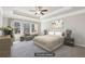 Well-lit main bedroom with tray ceiling, ceiling fan, and three large windows at 780 Mccart Rd, Lawrenceville, GA 30045